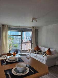 City Centre Snow Hill Apartment (Sleeps 6) في برمنغهام: غرفة معيشة بها طاولة وأريكة +36 صورة