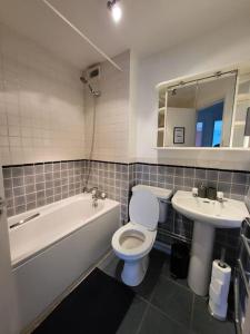 a bathroom with a tub and a toilet and a sink at City Centre Snow Hill Apartment (Sleeps 6) in Birmingham