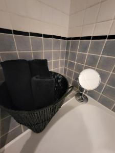 a bathroom with a black basket and a mirror at City Centre Snow Hill Apartment (Sleeps 6) in Birmingham