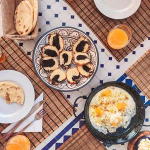 uma mesa com pequeno-almoço de ovos e torradas em Tassourt Lodge em Essaouira