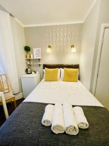 1 dormitorio con 1 cama con toallas en Trinity House Hotel, en Londres