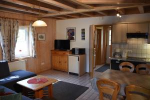 a kitchen and a living room with a table and a couch at Ferienhaus Nr 18B1, Feriendorf Hagbügerl, Bayr Wald in Waldmünchen