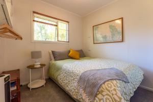 a bedroom with a bed and a window at Four Palms Cottage - Onetangi Holiday Home in Onetangi