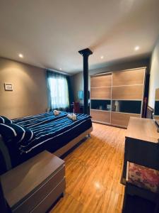 een slaapkamer met een bed met een blauw dekbed bij Opera Apartment in Tbilisi City