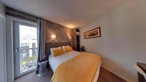 - une chambre avec un lit et une grande fenêtre dans l'établissement Hotel Acadie Les Ulis, aux Ulis