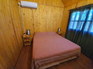 a bedroom with a bed in a wooden room at Chacra Mandala in Gualeguay +40 photos