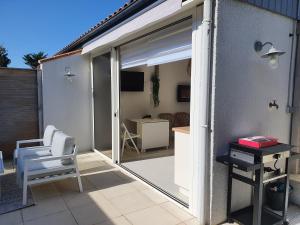 a sliding glass door to a patio with a chair at Superbe appartement au coeur du Cap-Ferret in Cap-Ferret