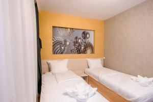 a room with two beds and a painting on the wall at Пиргуля in Miladinowzi
