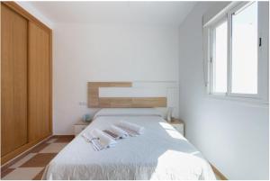 a white bedroom with a bed with two white towels at Apartamento, Casa, Chalet Adosado FRENTE AL MAR in Carboneras
