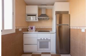 a kitchen with a stainless steel refrigerator and white cabinets at Apartamento, Casa, Chalet Adosado FRENTE AL MAR in Carboneras