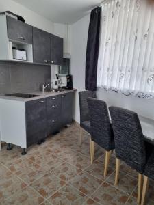 eine Küche mit einer Theke, Stühlen und einem Waschbecken in der Unterkunft QM Apartment in Triberg