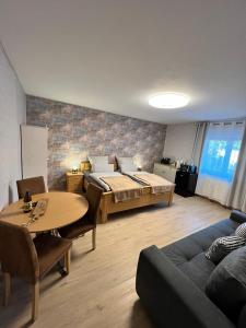a room with a bed and a table and a couch at O&W Ferienzimmer am Nürburgring, Quiddelbach in Quiddelbach