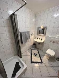 a bathroom with a tub and a toilet and a sink at Rooms4ring Privatzimmer am Nürburgring in Quiddelbach