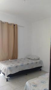 1 dormitorio con 2 camas y cortina en DUPLEX BEIRA MAR TABATINGA, en Nísia Floresta