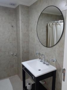 ein Bad mit einem Waschbecken und einem Spiegel in der Unterkunft Departamentos Apart PM in Necochea