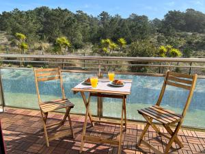 a table and chairs on a balcony with a view of the water at Seaven Ericeira Beach Studio in Ericeira