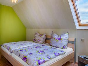 a bedroom with a bed with purple flowers on it at Apartment with balcony in Harz Mountains in Cattenstedt