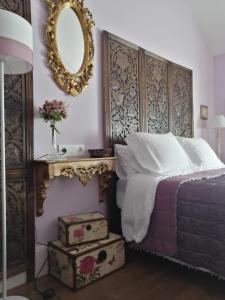 - une chambre avec un lit et un miroir mural dans l'établissement Casona Del Duende, à Alájar