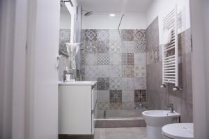 a bathroom with a sink and a toilet and a tub at Borgo San Giovanni Rooms Catania in Catania