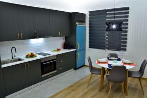 uma cozinha com armários pretos e uma mesa e cadeiras em Nana's house em Chalkida