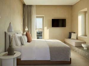 a bedroom with a large white bed and a couch at PAROCKS Luxury Hotel & Spa in Ambelas