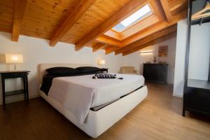 Un dormitorio con una cama grande en una habitación con techos de madera. en Maison Vespa, en Argegno