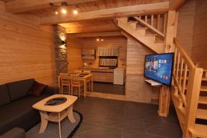 a living room with a television in a cabin at Domki Akwen in Rewal