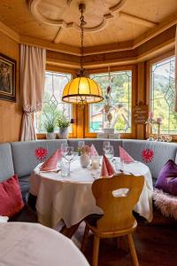een eetkamer met een tafel en een kroonluchter bij Restaurant Gästehaus Wiesenheim in Uderns