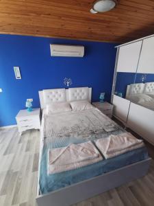 sypialnia z niebieskimi ścianami i dużym łóżkiem w obiekcie Mavi Akvaryum Pension w mieście Sogut