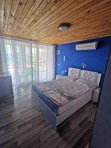 1 dormitorio con 1 cama grande y pared azul en Mavi Akvaryum Pension, en Sogut
