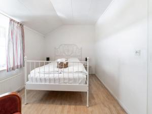a white crib in a room with white walls at Apartment in Ubachsberg near Limburg Trails in Voerendaal