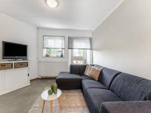 a living room with a couch and a tv at Apartment in Ubachsberg near Limburg Trails in Voerendaal +32 photos