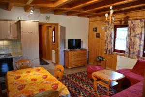 a kitchen and a living room with a table and a couch at Ferienhaus Nr 7B2, Feriendorf Hagbügerl, Bayr Wald in Waldmünchen