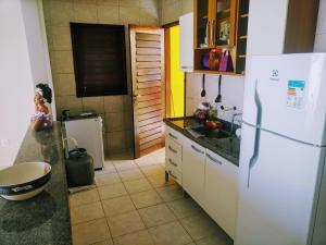 uma cozinha com um frigorífico branco e um lavatório em DUPLEX BEIRA MAR TABATINGA em Nísia Floresta