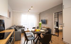 a kitchen and living room with a table and chairs at Apartament Nakielska 46a lux 40m2 in Bydgoszcz