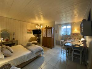 um quarto com uma cama e uma sala de jantar em Maison d'hôtes La Rose Laitière em Saint-Martin-sur-Écaillon