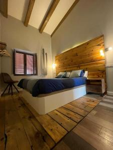a bedroom with a large bed with a wooden headboard at Las Gavias in Matapozuelos