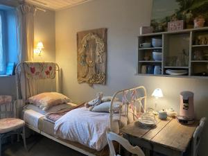 um quarto com uma cama e uma mesa de madeira em Maison d'hôtes La Rose Laitière em Saint-Martin-sur-Écaillon