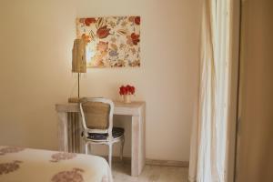 a bedroom with a desk with a chair and a painting at Sonora Jungle & Yoga Retreat in Puerto Viejo