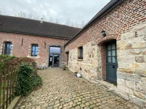 a brick building with a door and a brick driveway at Maison d'hôtes La Rose Laitière in Saint-Martin-sur-Écaillon
