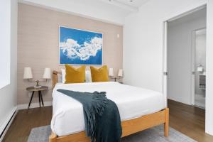 a bedroom with a large white bed with yellow pillows at Bakan- Palais des Congres, Convention Centre in Montréal