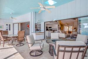 ein Wohnzimmer mit einem Deckenventilator sowie einem Tisch und Stühlen in der Unterkunft Sand Bunker in Rotunda-West