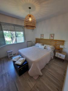 Un dormitorio con una cama grande y una lámpara de araña. en AP apartment Las Lomas en Martínez