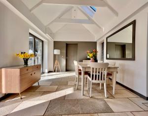 a dining room with a table and chairs and a mirror at Gwel an Heyl, Padstow in Little Petherick