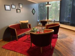 sala de estar con sofá rojo, mesa y sillas en Marín Apartments en Puerto Iguazú