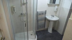 a bathroom with a shower, sink, and toilet at Arran House Hotel in London