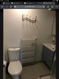 een badkamer met een wit toilet en een wastafel bij Studio coeur de Luc/Mer in Luc-sur-Mer