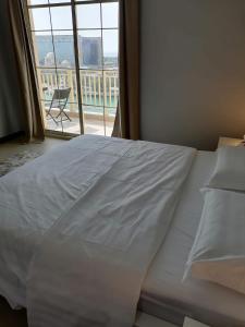 a large white bed in a room with a window at الهُدىٰ غرفة إطلالة بحرية - عائلات One Room Sea View-ALHUDA in King Abdullah Economic City +22 photos