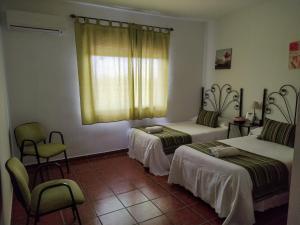 a room with two beds and a window at Casa Rural La Aduana in Villanueva del Fresno