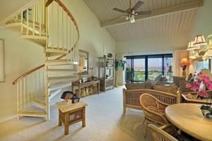 a living room with a spiral staircase and a couch at Hanalei Bay Resort 7302 in Princeville